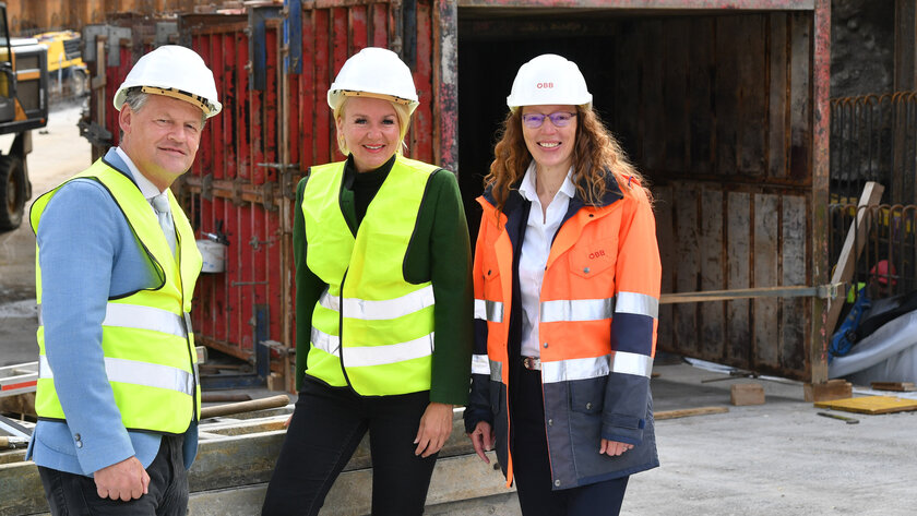 Bürgermeister Christian Scheider, Stadträtin Sandra Wassermann, BA und Christiane Schiavinato, Projektleiterin ÖBB-Infrastruktur AG, besichtigen den Baufortschritt in Waidmannsdorf. 